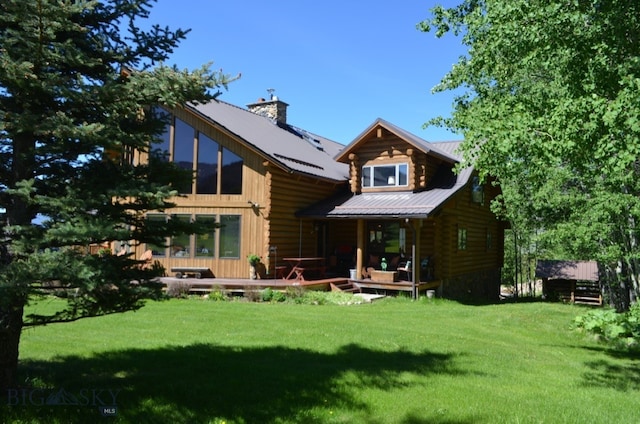 rear view of house with a yard and a wooden deck