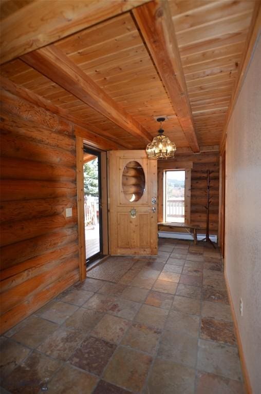 155 Moose Run, Polaris, MT 59746 - entryway featuring healthy amount of natural light, a wood ceiling with exposed beams, a chandelier, rustic walls, and dark stone finish floors