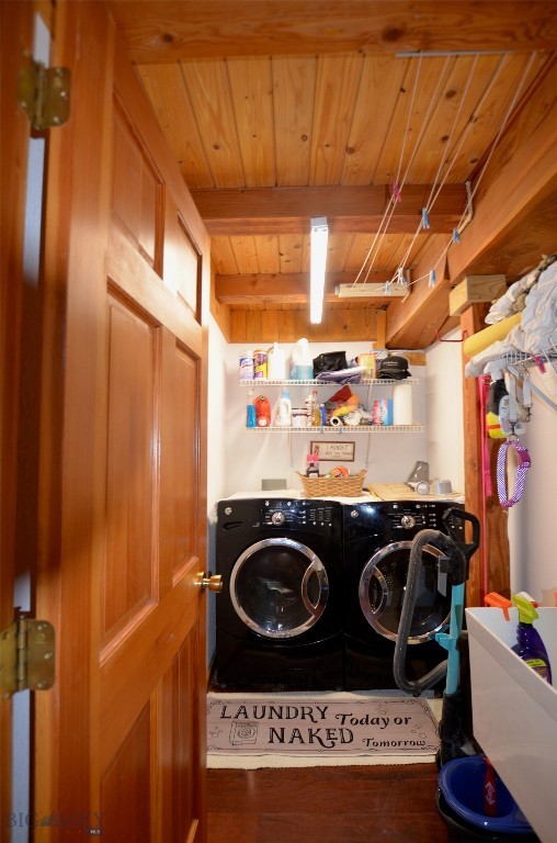 washroom with dark wood-type flooring, washer and dryer, and wood ceiling