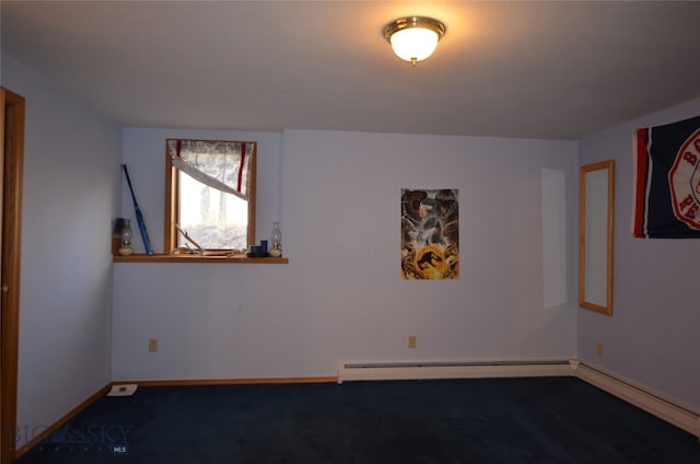 empty room featuring a baseboard radiator and dark carpet