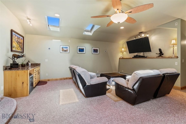 carpeted cinema with vaulted ceiling with skylight and ceiling fan