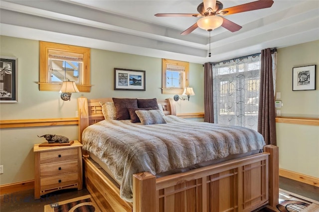 bedroom featuring ceiling fan, a raised ceiling, and access to outside