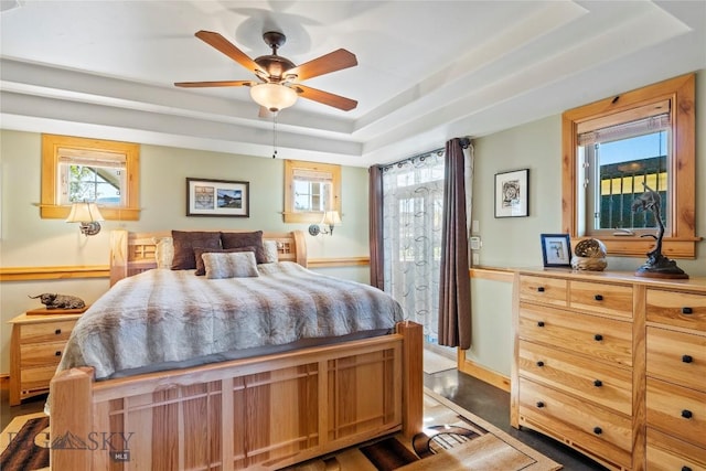 bedroom featuring a raised ceiling and ceiling fan