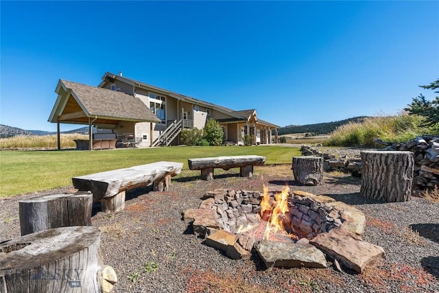 view of yard with a mountain view, a jacuzzi, and an outdoor fire pit