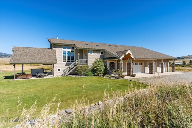 view of front of property featuring a garage, a hot tub, and a front lawn