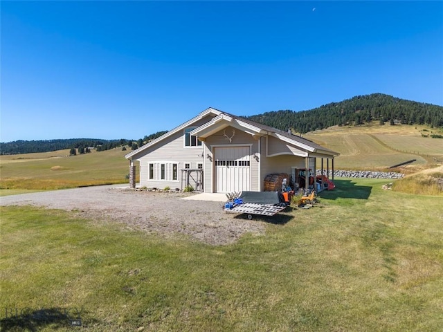 exterior space featuring a garage, a yard, and a rural view