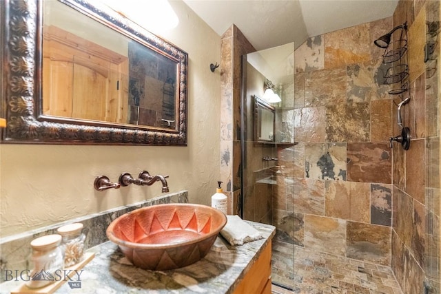 bathroom with sink and tiled shower