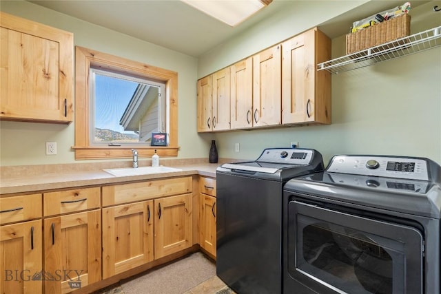 laundry area with cabinets, independent washer and dryer, and sink