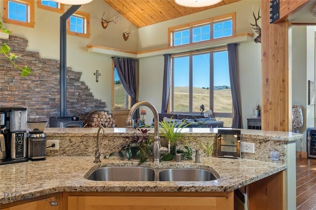 kitchen featuring lofted ceiling, sink, hardwood / wood-style flooring, light stone counters, and a mountain view