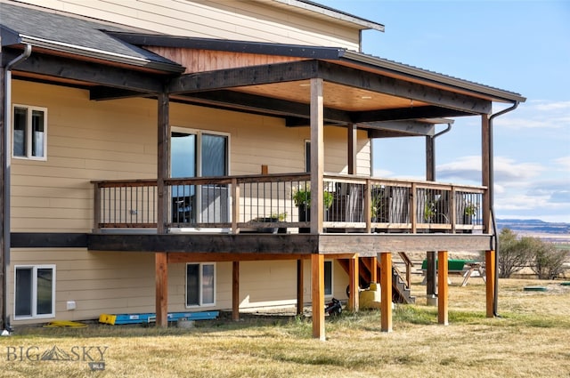 rear view of house with a wooden deck and a yard