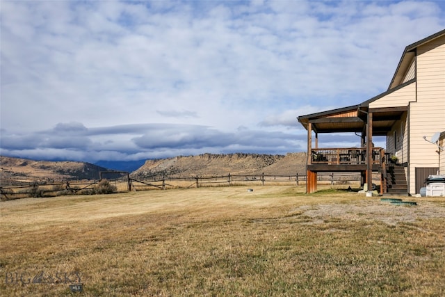 view of yard with a deck with mountain view and a rural view