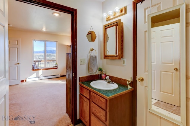 bathroom featuring baseboard heating and vanity