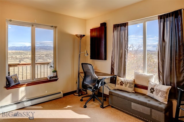 carpeted home office with a mountain view, a baseboard heating unit, and a wealth of natural light