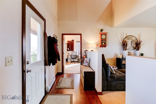 hall featuring baseboard heating and dark hardwood / wood-style flooring