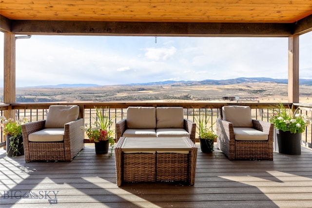 wooden deck with a mountain view and an outdoor living space