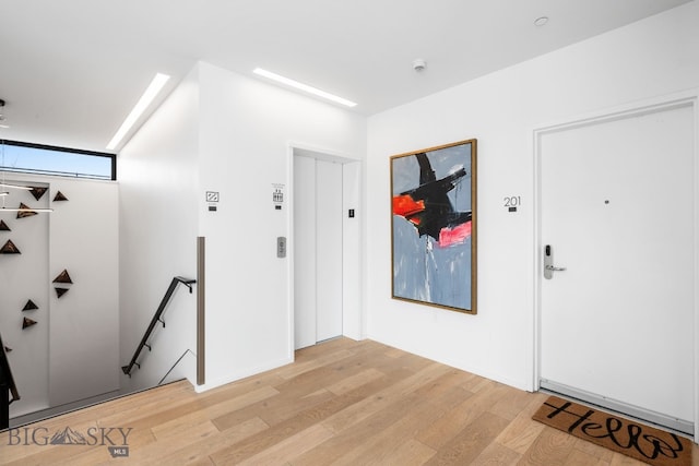 foyer entrance with elevator and light hardwood / wood-style flooring