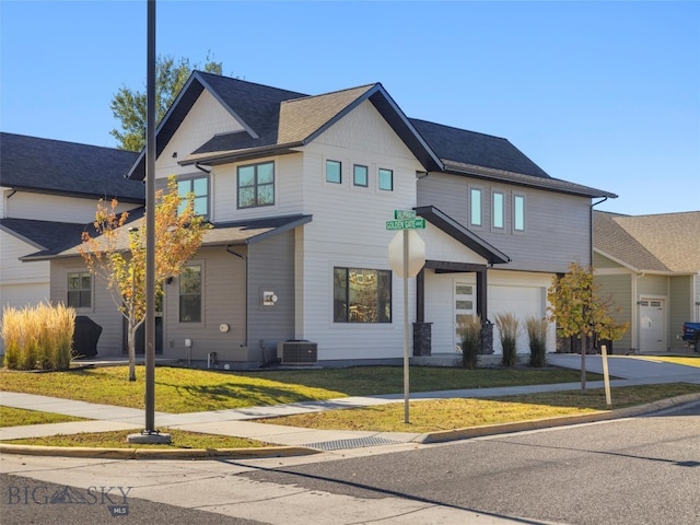 view of front of home featuring cooling unit, a front lawn, and a garage