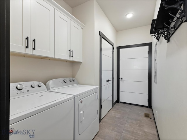 laundry area featuring independent washer and dryer and cabinets