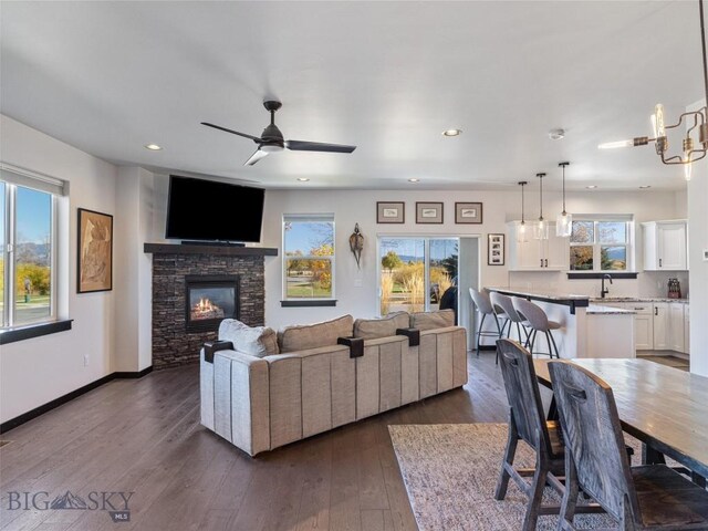 1015 Golden Gate Ave Unit A, Bozeman, MT 59718 - living area with a stone fireplace, recessed lighting, ceiling fan, dark wood-type flooring, and baseboards