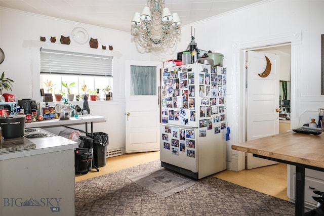 kitchen featuring white refrigerator, a notable chandelier, and crown molding