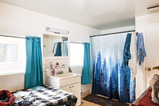 carpeted bedroom with a wall unit AC and sink