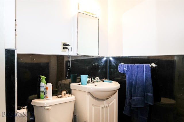 bathroom featuring vanity, toilet, and tasteful backsplash