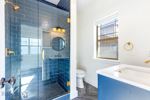 bathroom with vanity, parquet floors, toilet, and an enclosed shower