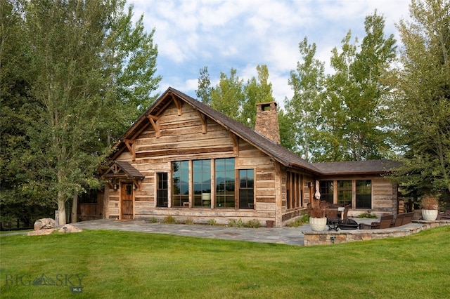 back of house with a patio and a lawn