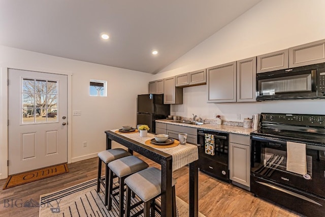 411 Brookline St Unit B, Livingston, MT 59047 - kitchen with black appliances, gray cabinetry, light wood-style flooring, lofted ceiling, and a sink