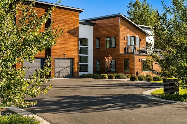 contemporary home featuring a balcony and a garage