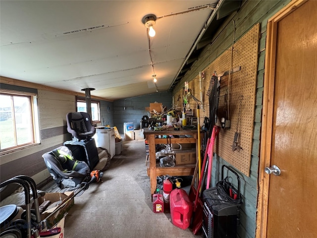 miscellaneous room featuring a workshop area, lofted ceiling, and concrete flooring