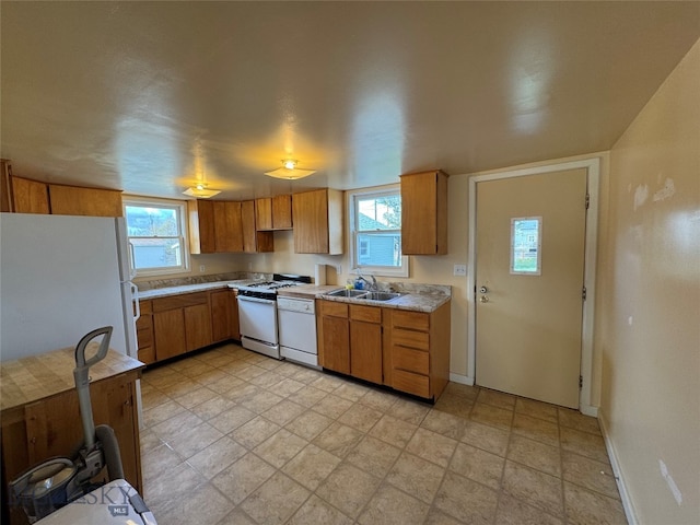 kitchen featuring white appliances, sink, and a wealth of natural light