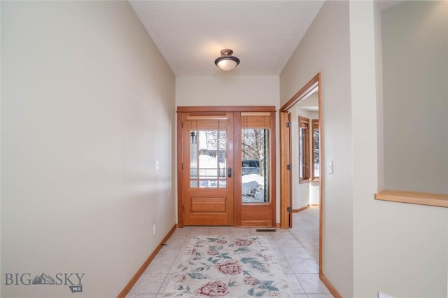 doorway with light tile patterned floors and french doors