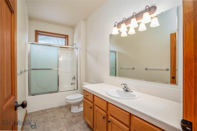 full bathroom with toilet, vanity, and bath / shower combo with glass door