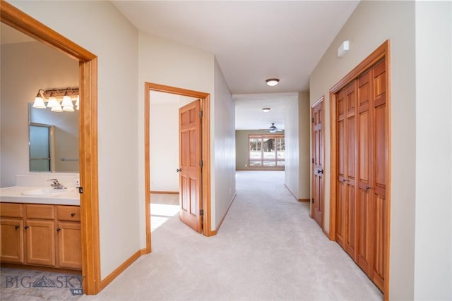 corridor with sink and light carpet