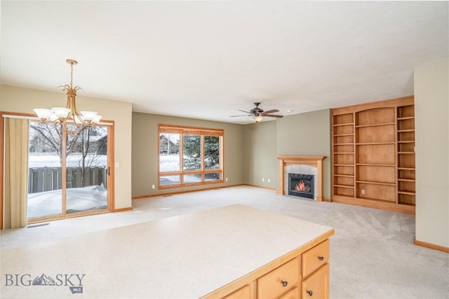 living room with ceiling fan with notable chandelier, a tile fireplace, and light carpet