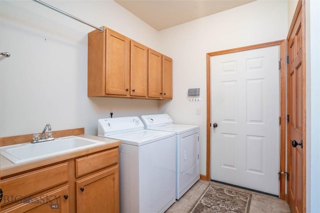 laundry area featuring cabinets, light tile patterned flooring, sink, and washer and clothes dryer