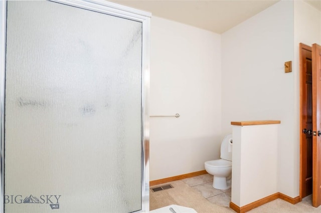 bathroom featuring walk in shower and toilet