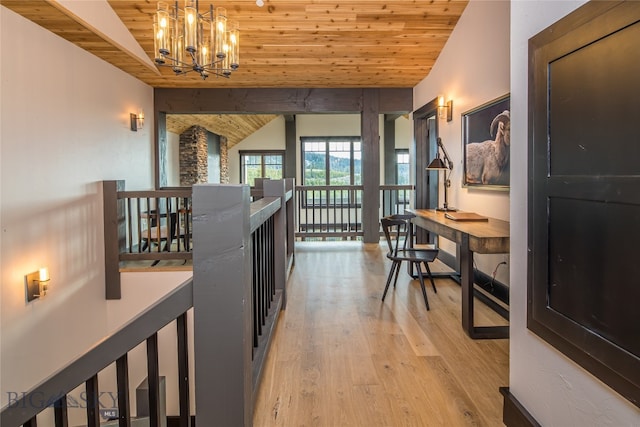 hall with vaulted ceiling, light hardwood / wood-style floors, wood ceiling, and a chandelier