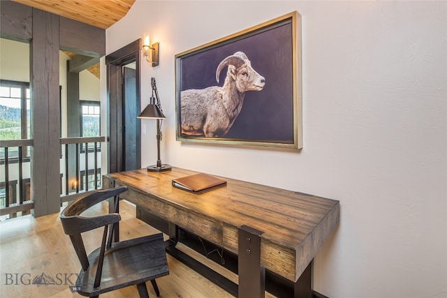 office area with light hardwood / wood-style flooring and wooden ceiling