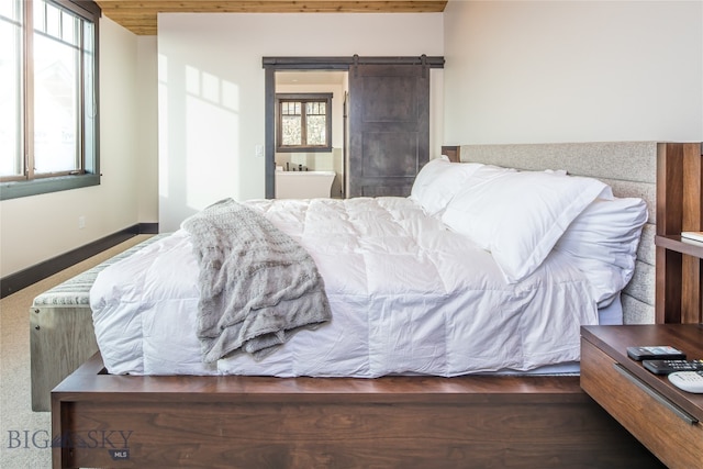 carpeted bedroom featuring a barn door