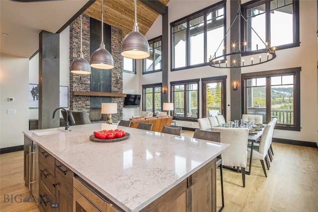 kitchen with decorative light fixtures, light stone counters, and plenty of natural light