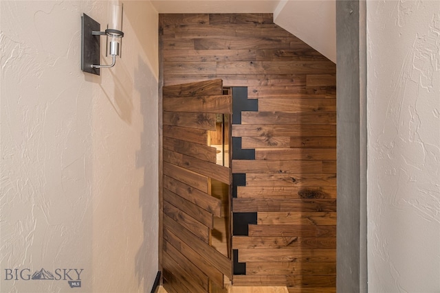 bathroom with vaulted ceiling and wood walls