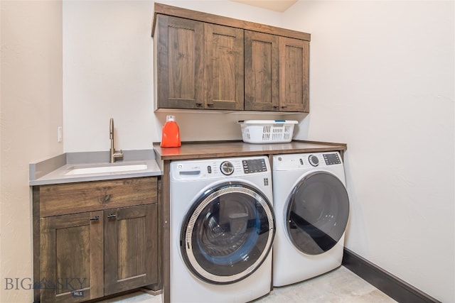 washroom featuring washer and dryer, cabinets, and sink