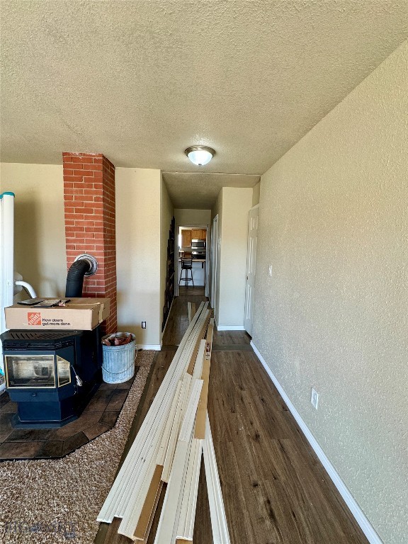 hallway with a textured ceiling and dark hardwood / wood-style floors