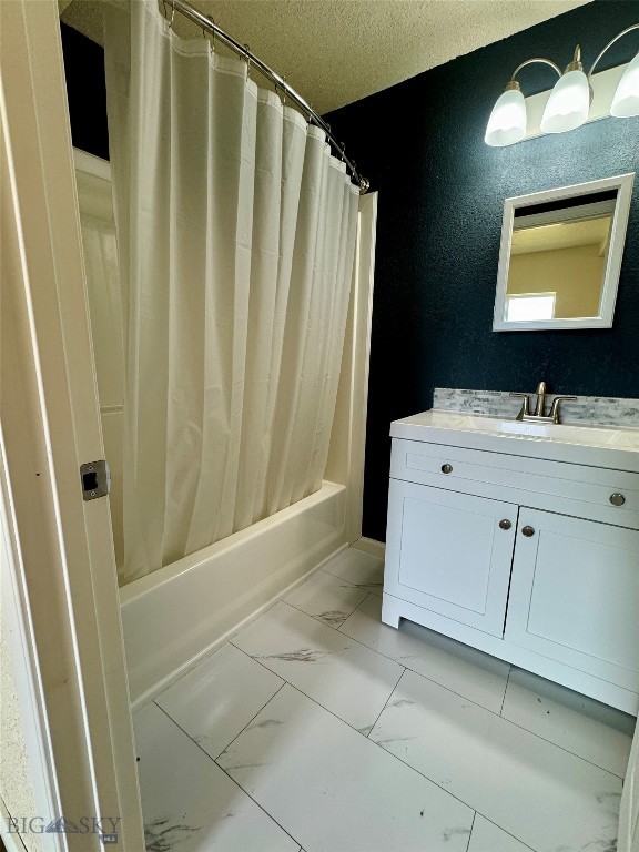 bathroom featuring vanity, shower / bath combination with curtain, and a textured ceiling