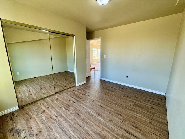 unfurnished bedroom with hardwood / wood-style flooring and a closet