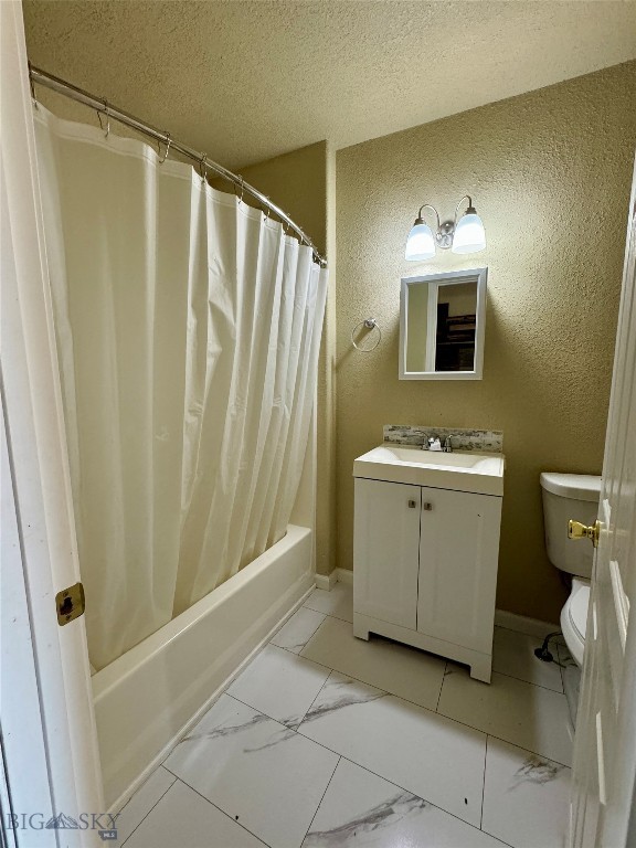 full bathroom featuring vanity, toilet, a textured ceiling, and shower / tub combo