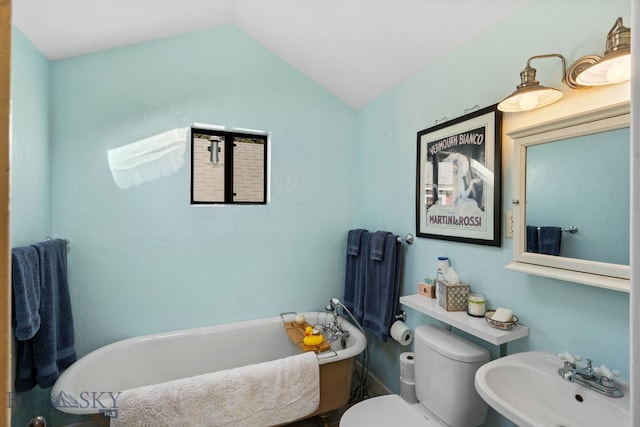 bathroom with toilet, sink, vaulted ceiling, and a bathing tub