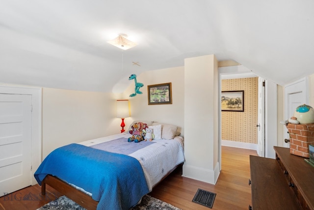 bedroom featuring wood-type flooring and vaulted ceiling